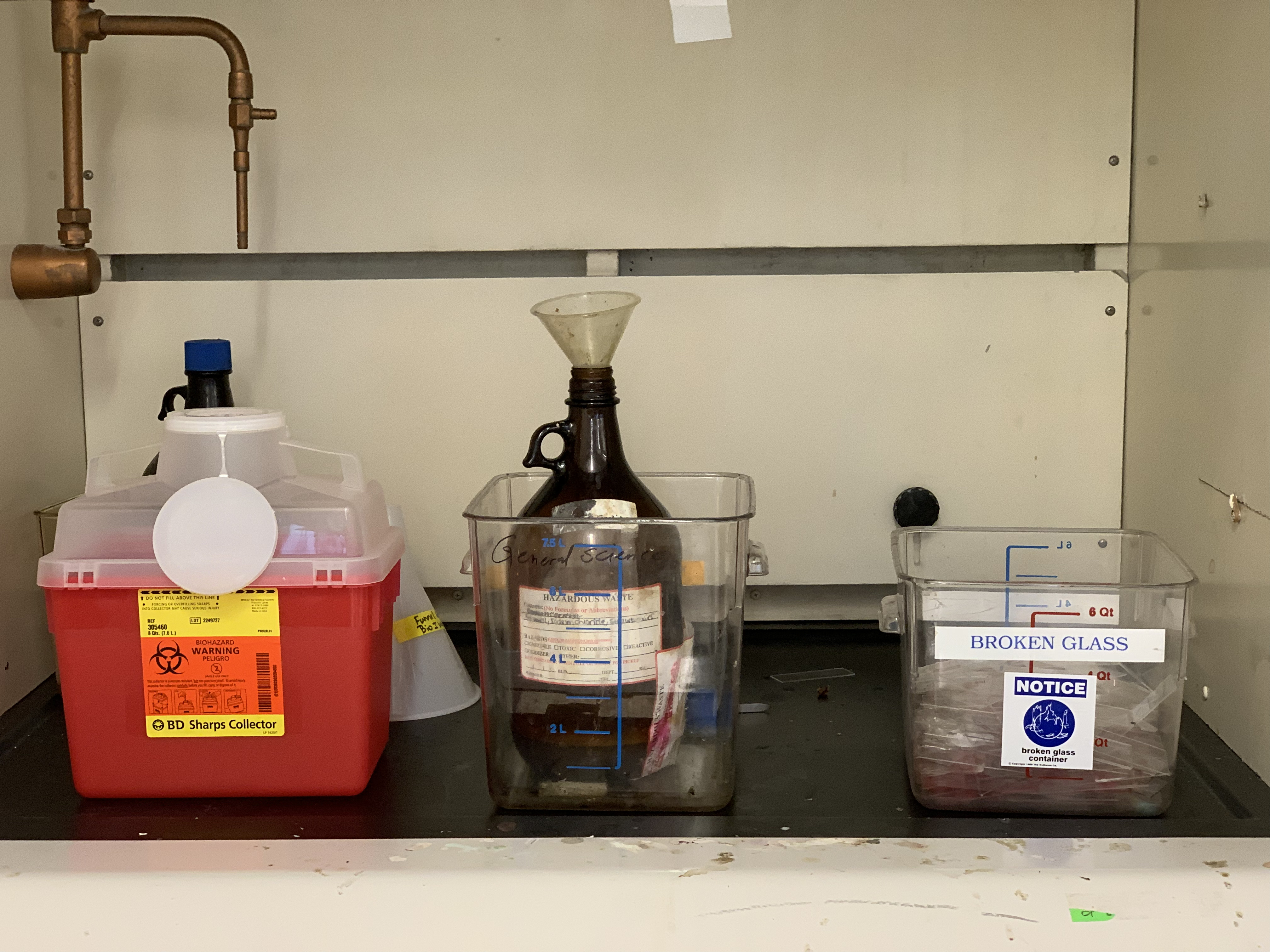 Waste containers for sharps, liquids and broken glass in the fume hood.